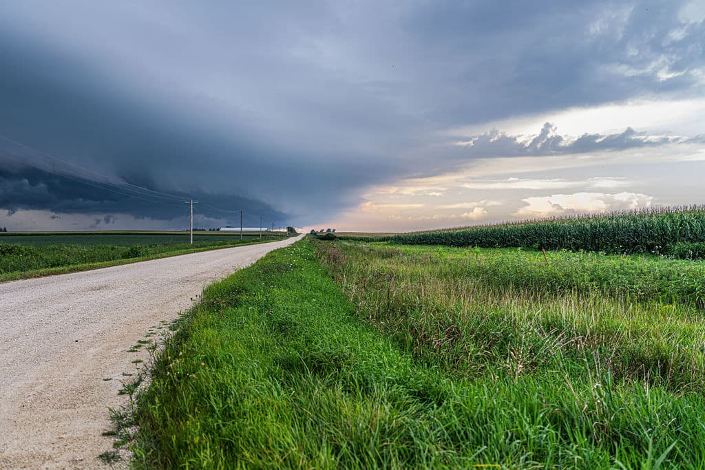 Storm clouds over a gravel road at the field edge