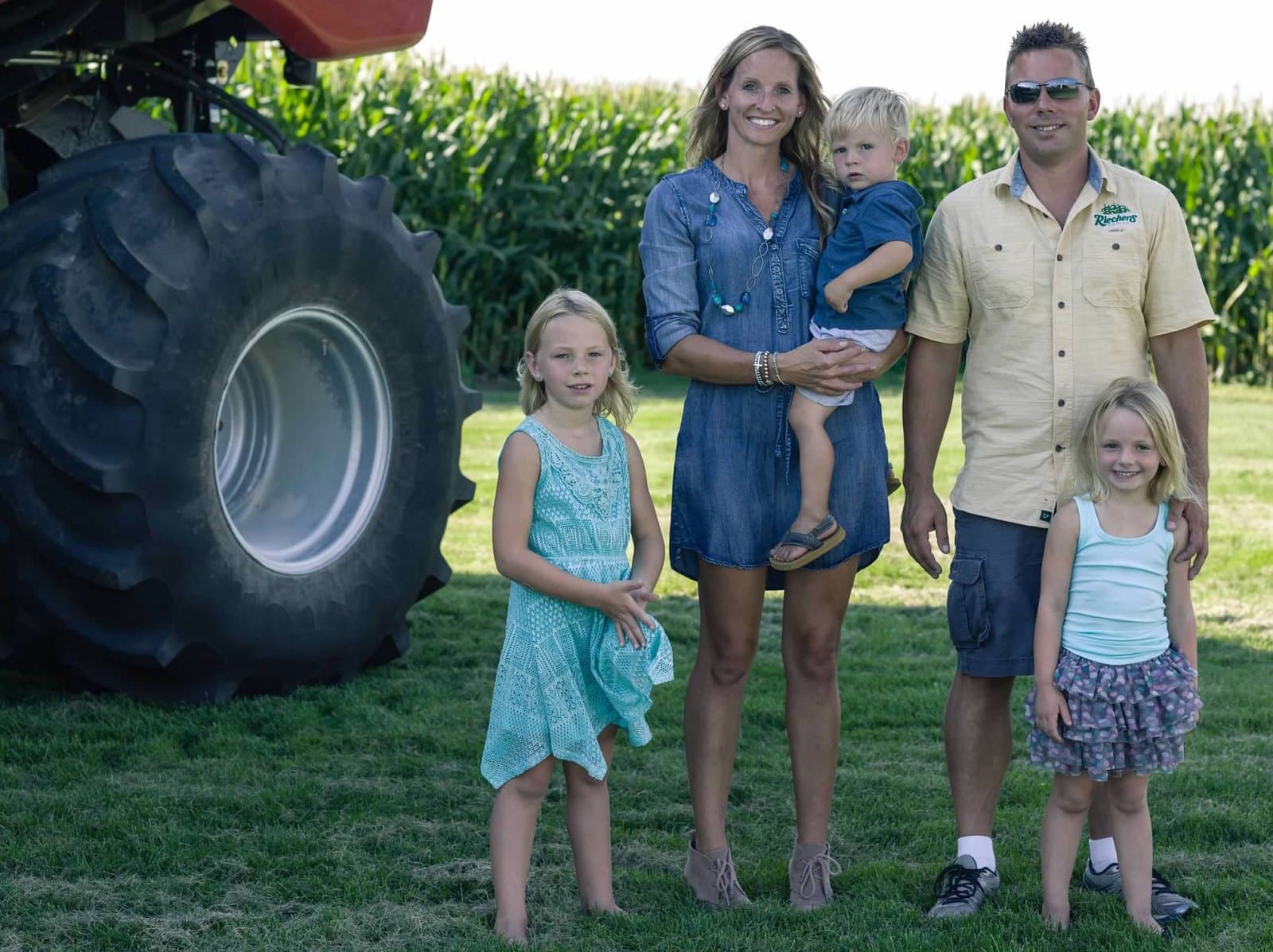 Ryan, Julie, and the kids beside the combine tire, 2016
